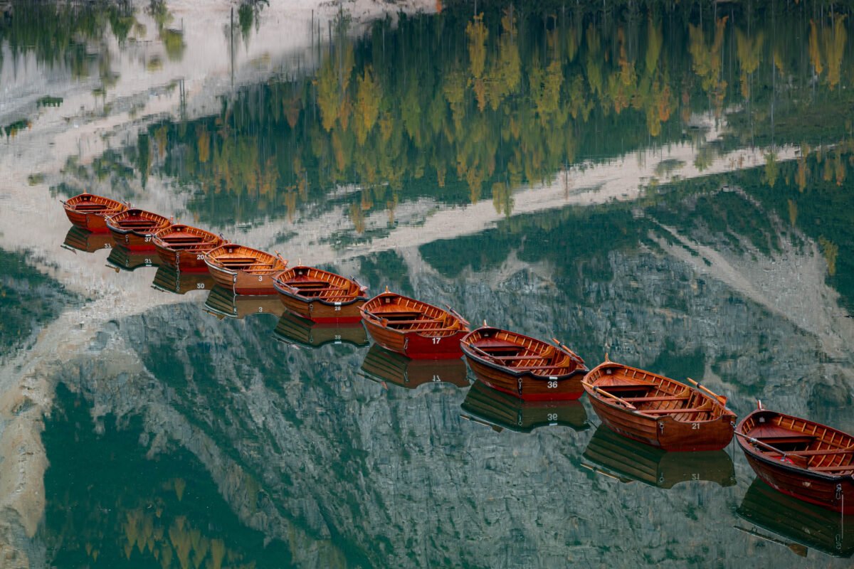 Rowing boats Lago di Braies morning light reflection
