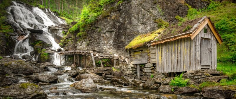 Landscape of waterfall in Norway with cabin