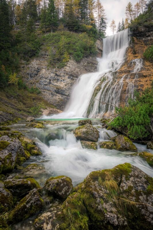 Waterfall with mist and sunlight through the trees