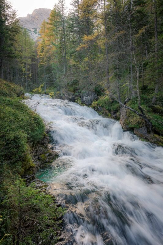 Waterfall among green vegetation in the Fanes valley